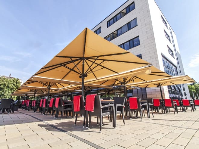 Restaurant terrace with many sun umbrellas in front of a building